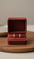 Velvet-lined burgundy jewelry box with hoop earrings